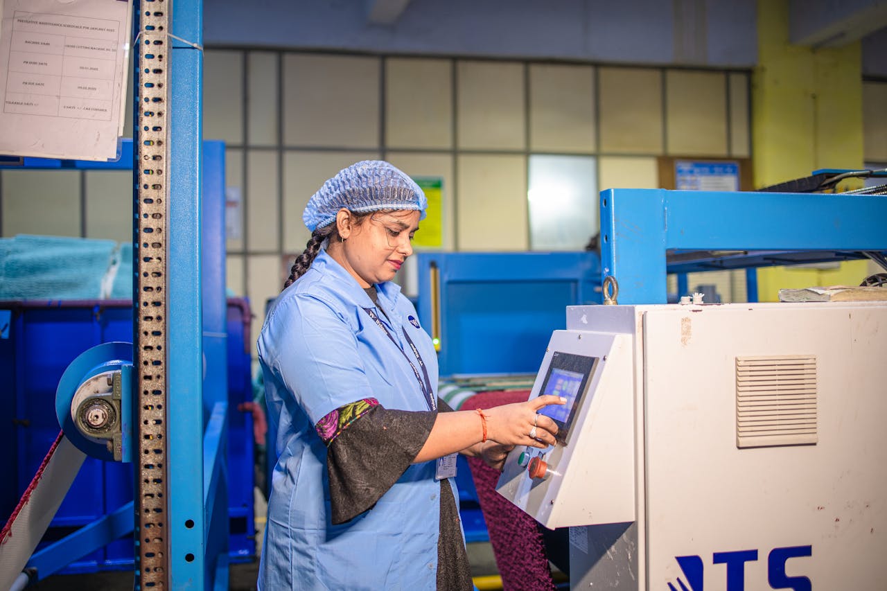Woman in a textile factory operating machinery, showcasing modern industry.